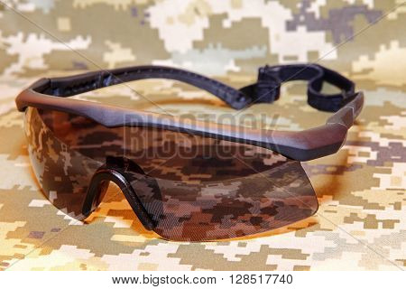 The Military tactical goggles on camouflage background.