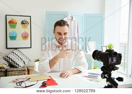 Young male blogger recording video at home