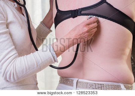 female doctor is listening to lunge of female patient