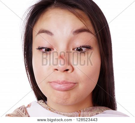 young asian woman looking cross-eyed at red pimple on her nose