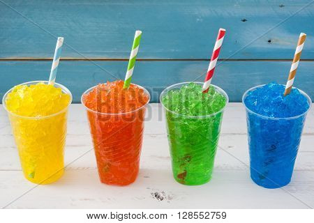 Fresh colorful summer slushies on blue wood