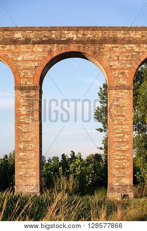 Arch section of the Nottolini Aqueduct in Tuscany near Lucca Italy. Warm evening light with classic Tuscan textures and tones. Concepts could include Travel Architecture Europe others.