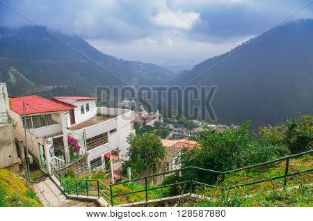 Charming village of Guapulo in Quito Ecuador with houses built downward valley, spectacular view Andes mountains.