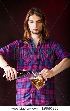 Alcohol liquor drinking relax party concept. Tapster fills stein from bottle. Young male bartender empties beer into glass.