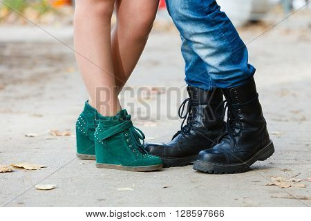 Fashion footwear dating romance love youth outdoor concept. Young lady meeting rough boy. Elegant girl in glamour shoes with man in jeans boots.