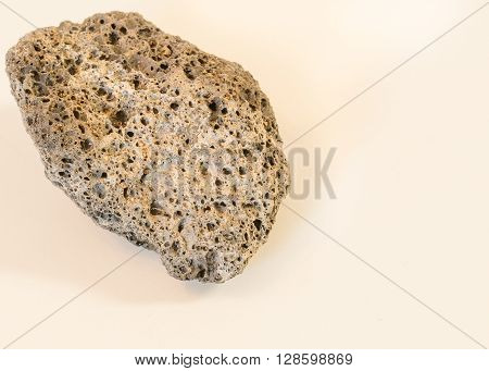 close up, small rock with many holes upper left