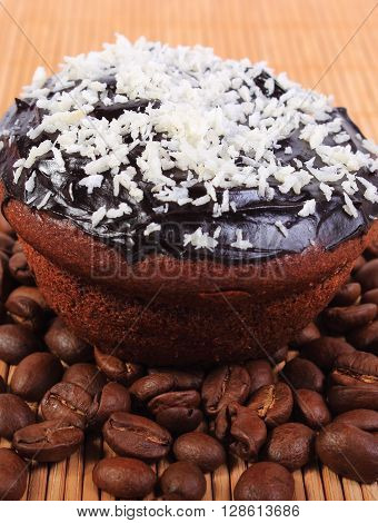 Homemade delicious fresh baked chocolate muffins with desiccated coconut and coffee grains on wooden background concept for dessert