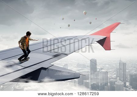 Guy sakting on airplane wing