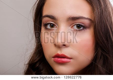 Portrait of a gorgeous brunette on a light background. Chic hair eyes and eyebrows.
