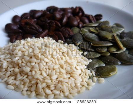 Gourd And Sesami Seed With Coffee Beans On A White Plate