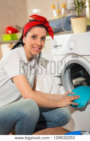 Young woman has a laundry day at home she takes the laundry out of your washing machine