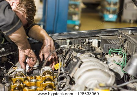 Hands Repairing A Car Engine With A Wrench