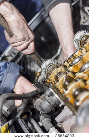Hands Repairing A Car Engine With A Wrench