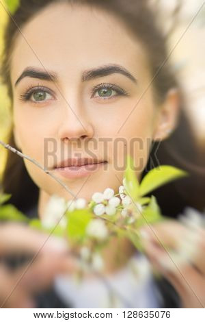 sensual young woman in cherry flowers blurred image