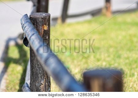 fragment of an old column and poles from a wooden fence for the ranch closeup on an indistinct background