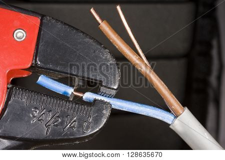 Trimming three core wire ready to fit to electrical appliance.