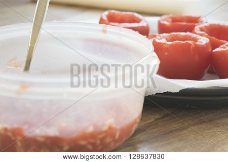 preparing tomatoes stuffed with rice with the removal of the pulp and the seeds