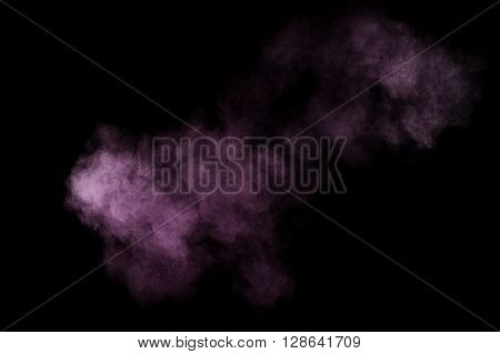 Purple powder explosion on black background. Colored powder cloud. Colorful dust explode. Paint Holi.