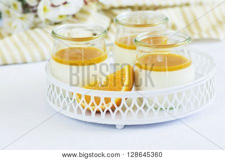 Vanilla panna cotta with exotic fruits sauce over dark wooden table. Selective focus
