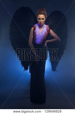 Beautiful female succubus. Concept photo in studio, on dark background