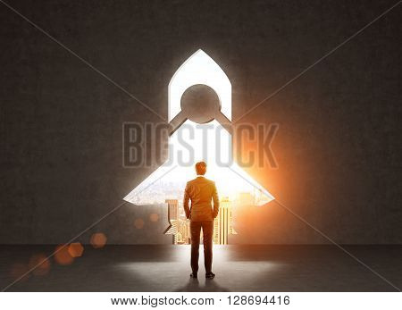 Start up concept with businessman standing in front of rocket shaped gap in wall revealing sunlit New York city view