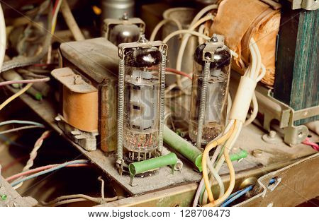 Selective focus on dusty vintage tube inside retro radio station. Old style technology