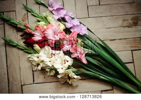 Beautiful Stylish Bouquet Of Colorful Gladioli On Wooden Rustic Background