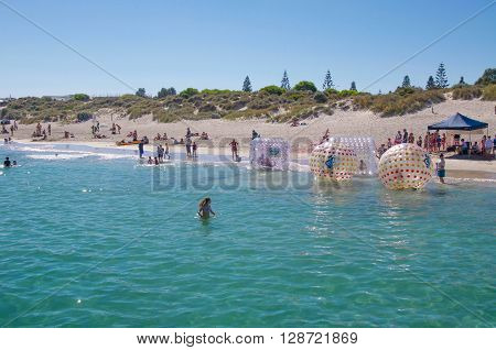 COOGEE,WA,AUSTRALIA-APRIL 3,2016: Coogee Beach Festival scene with families and floating inflatable water balls in the Indian Ocean waters of Coogee, Western Australia.