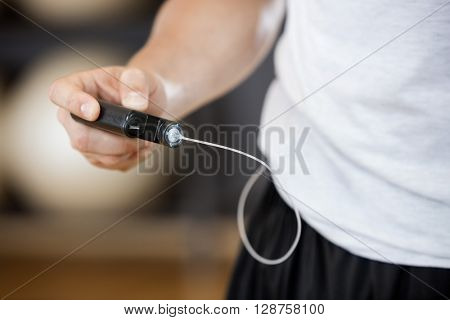 Midsection Of Man Using Glucose Monitor In Gym
