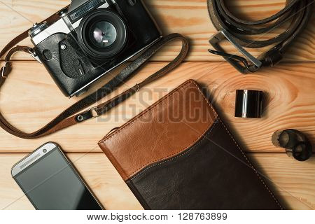 Camera, notebook and mobile phone on a wooden background. Still life. top view