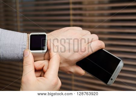 Phone and smart watch on a male hand. Mock up. Back view