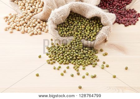 Assortment Of Beans And Lentils In Hemp Sack On Wooden Background. Green Bean, Groundnut, Soybean, R