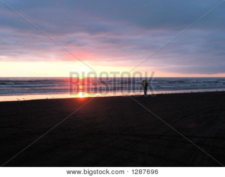 Mann am Strand bei Sonnenuntergang