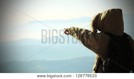 Young Explorer With Winter Jacket And Backpack Indicates The Horizon From Above The Top Of The Mount