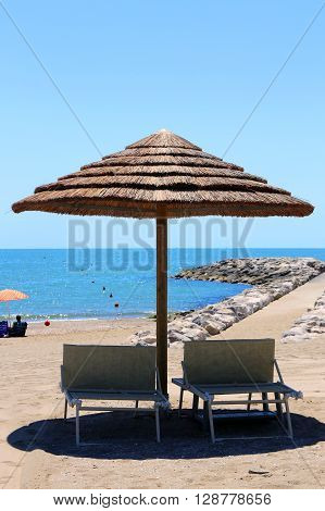 Beach With Parasols Made With Bamboo And Straw In The Resort