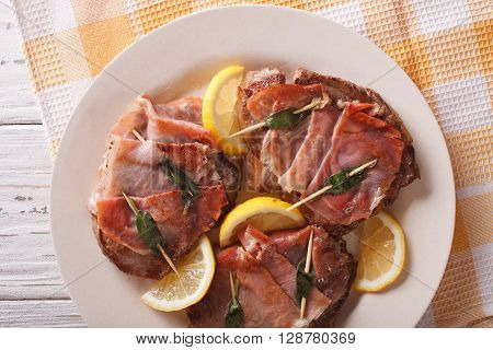 Italian Cuisine: Beef Saltimbocca With Lemon Close Up. Horizontal Top View