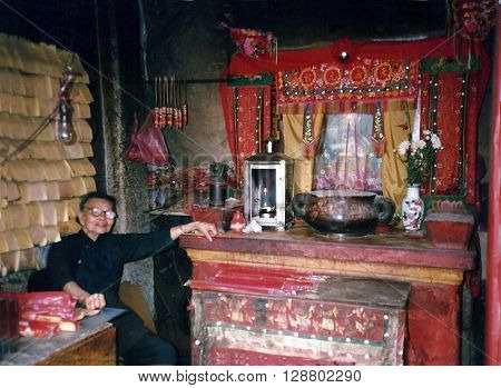 MACAU - CIRCA 1987: An elderly woman sits inside the A-Ma Temple, built in 1488, and dedicated to Matsu, the goddess of seafarers and fishermen.