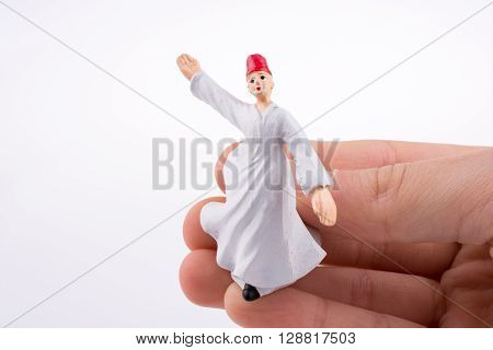 Hand holding a Sufi Dervish on a white background