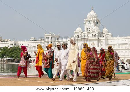 AMRITSAR INDIA - SEPTEMBER 26 2014: Unidentified Sikhs and indian people visiting the Golden Temple in Amritsar Punjab India. Sikh pilgrims travel from all over India to pray at this holy site