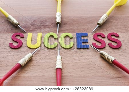 Six dart run in to success target on wooden background. Group of dart (Teamwork) run in to Success target. Abstract success background concept