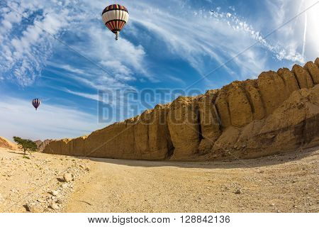 Huge multi-colored balloon over the hot desert. Stone desert near the seaside resort of Eilat. 
