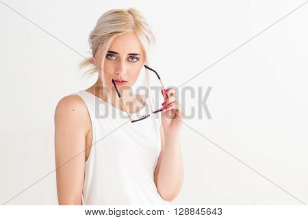 Sexy confident young woman with sunglasses . Fashion model in sunglasses on white background. Concept for advertisement, flyer, banner. Beautiful sexy girl with glasses looking at the camera