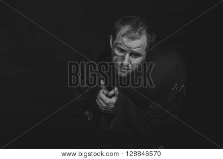Beautiful and fascinating game theater actor on camera. Black and white photo of the actor in the guise of a beggar on a dark background. Beautifully decorated stage image and professional makeup.