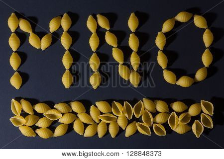 English alphabet laid out in the form of pasta shells , shot against a dark background.