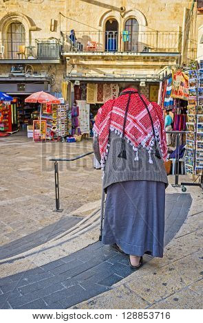 JERUSALEM ISRAEL - FEBRUARY 18 2016: The senior Palestinian in traditional red kufiya and galibaya in Omar Ben el-Hatab street on February 18 in Jerusalem.
