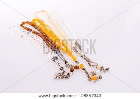 Colorful Tespihs that is prying beads on a white background
