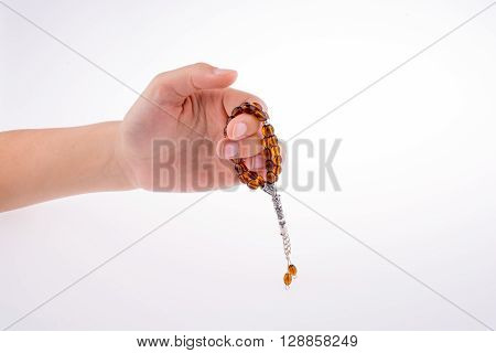 Hand holding a tespih on a white background
