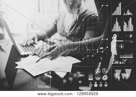 Business concept photo.Meeting of investment managers.Woman showing repots.Man using modern laptop. Graphic icon, worldwide stock exchanges interfaces. Horizontal. Film effect. Black and White