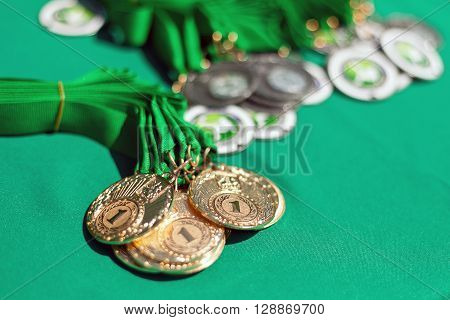 Gold medals of winners on a green background. Gold medals of prize-winners. First place.