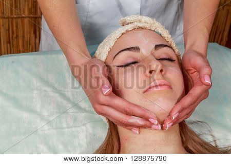 Girl with a beautician at spa salon. Beautician performs cosmetic procedures.applying cosmetic cream. Cosmetology facial beauty - The concept of facial skin care. Article about cosmetology.